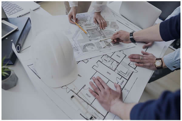 Photo of a construction hard hat on top of blueprints.